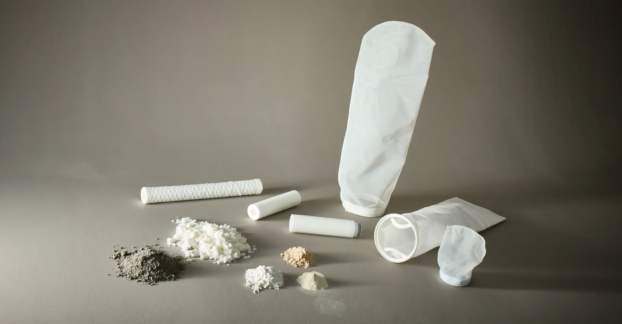 Filterzakken, filtercartridges en filtratiemedia met poeders en vezels